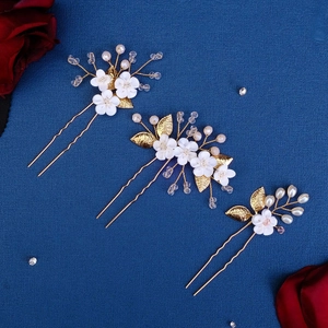 Detailed view of handmade flower hair pins with crystals and pearls for bridal hairstyles