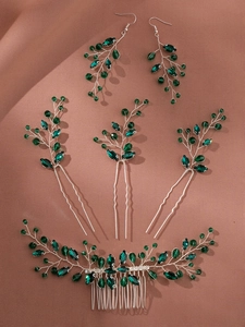 Détail d'un peigne à cheveux de mariée et boucles avec cristaux verts et fils d'argent