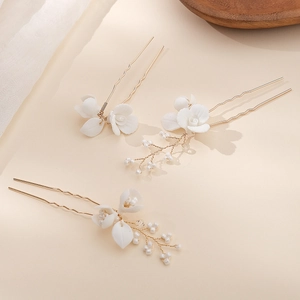 Détail de trois épingles à cheveux fleurs en céramique blanche avec fil d'or et perles