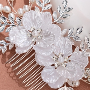 Détail de peigne à cheveux pour mariée avec fleurs blanches et perles sur soie rose