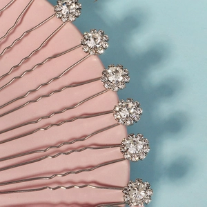 Détail macro d'épingles à cheveux en U avec strass tournesol sur un plateau rose