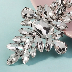Détail macro d'une barrette argentée ornée de strass étincelants en taille poire et marquise