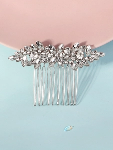 Detailed close-up of a bridal hair comb with silver leaf design and clear rhinestones