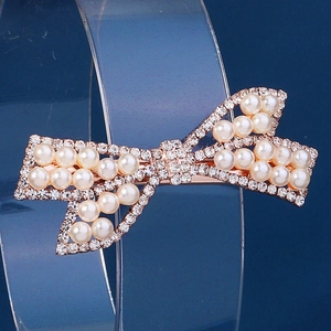 Elegant rose gold butterfly hair clip with white pearls and sparkling rhinestones