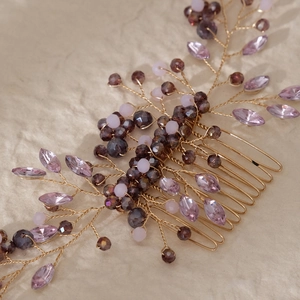Macro detail of handmade gold bridal hair comb with purple crystals and pink beads