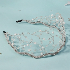 Detail of handmade silver wire bridal headband with crystals and white beads on blue base