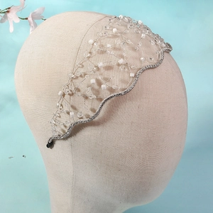 Close-up of handmade bridal headband with white crystal beads and silver wire mesh