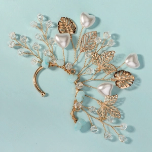 Detail of handmade crystal flower ear cuff with gold leaves, heart pearls and blue stones