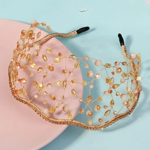 Detail of handcrafted gold mesh headband with amber crystals and sparkling rhinestones