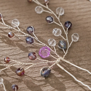 Detail of handcrafted bridal hair pin with purple crystal beads and silver wire design