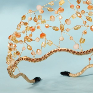 Macro detail of handmade gold wire bridal headband with colorful beads and rhinestones
