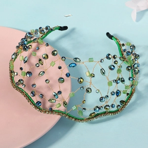 Macro detail of handmade bridal headband with blue crystals and green woven mesh
