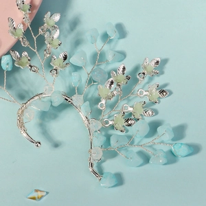 Detail of silver leaf ear cuff with blue crystals and handmade wire wrap craftsmanship