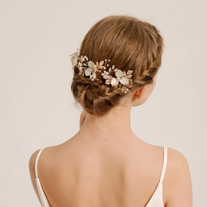 Peigne à cheveux de mariée avec fleurs dorées, perles et cristaux sur modèle