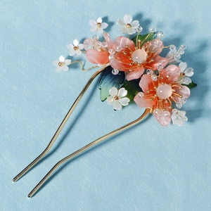 Vue macro détaillée de l'épingle à cheveux fleur de pêcher avec cristaux et feuilles vertes
