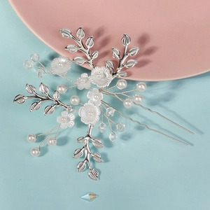 Détail d'épingle à cheveux de mariée avec fleurs faites main, perles et cristaux