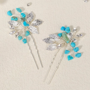 Detailed macro of silver bridal hair pins featuring turquoise stones and crystal leaves
