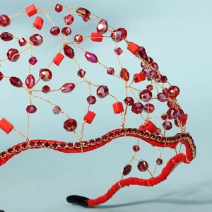 Detail of handmade red crystal mesh headband with intricate beaded weaving and rhinestones