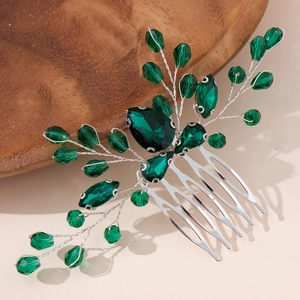 Silver bridal hair comb with emerald green crystals in a nature-inspired leaf design