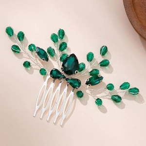 Close-up of handmade bridal hair comb with emerald green crystals and silver wire work