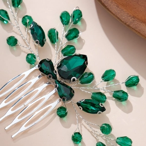 Close-up of handmade emerald crystal hair comb with intricate silver wire wrapping detail