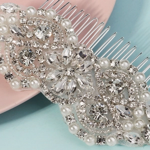 Macro shot of silver bridal hair comb with luxury rhinestones and white faux pearls