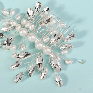 Macro shot of silver bridal hair comb with woven pearls and marquise rhinestones