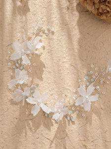Detail of bridal hair vine with white fabric flowers, pearls, and crystals on wire