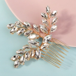 Handmade bridal hair comb with gold wire and marquise crystal leaves on a soft background
