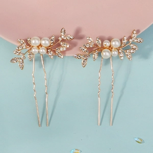Macro-opname van gouden bruidshaarspelden met kristallen en witte parels voor haarstyling