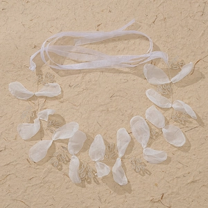 Detail of handmade white organza flower headband with silver wire and satin ribbon ties