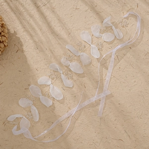 Detailed macro view of delicate white organza flower petals on a handmade bridal hairband