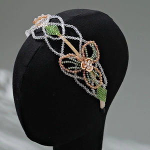 Detailed macro view of handmade crystal bead floral patterns on a gold bridal headband