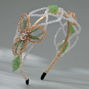 Handmade beaded headband with green and amber crystals and floral pearl detail