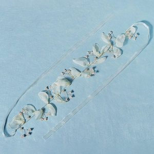 Detailed macro of handmade floral bridal headband with green organza leaves and pink pearls