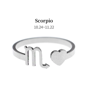 Detail of silver Scorpio zodiac sign and heart on an open stainless steel ring