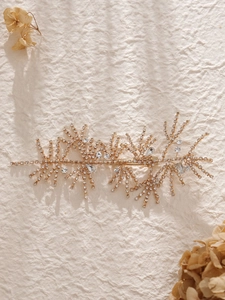 Detail of luxury bridal hair clip with sparkling rhinestones on golden branch design