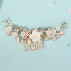Dettaglio del pettine per capelli sposa con foglie in lega dorata e fiori in ceramica