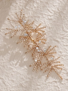 Detailed macro view of golden vine hair clip with radiant rhinestones and intricate metal wire