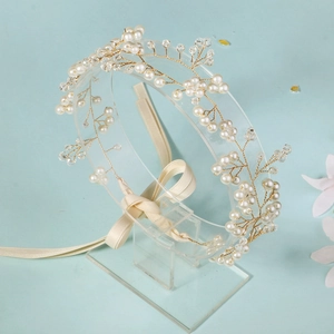 Détail d'un bandeau de mariée fait main avec perles blanches, cristaux et rubans