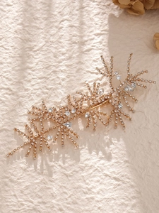 Close-up of gold bridal hair clip with sparkling rhinestones and crystal flower detailing