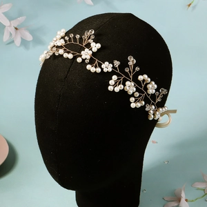 Détail d'un bandeau de mariée fait main avec perles blanches et cristaux sur un mannequin