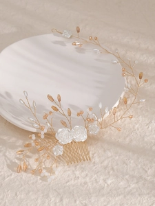 Detailed close-up of handmade gold wire bridal hair comb with white resin roses and pearls