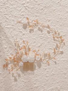 Detail of bridal hair comb with white resin roses, pearls, and golden vine design
