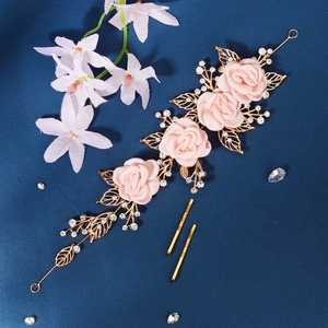 Detailed close-up of pink fabric roses and golden leaves bridal hair comb with crystals