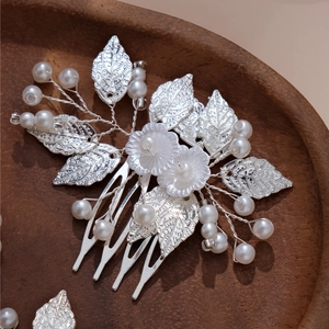 Silver bridal hair comb with handmade metal leaves and white pearls for wedding styling