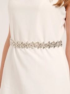 Detail of bridal rhinestone flower belt on white dress for wedding party accessory