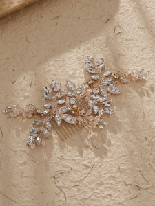 Detaillierte Nahaufnahme des goldenen Brauthaarkamms mit glitzernden Strasssteinen und Blättern