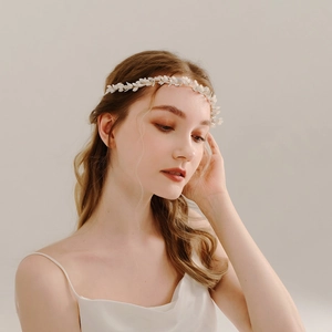 Détail du bandeau de mariée avec fleurs blanches et cristaux sur une femme