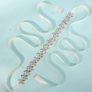 Close-up of bridal belt with white satin ribbon and sparkling crystal flower patterns